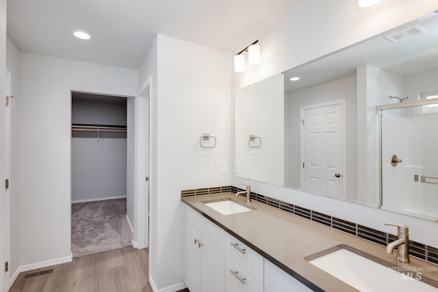 bathroom featuring hardwood / wood-style flooring, vanity, and a shower with door