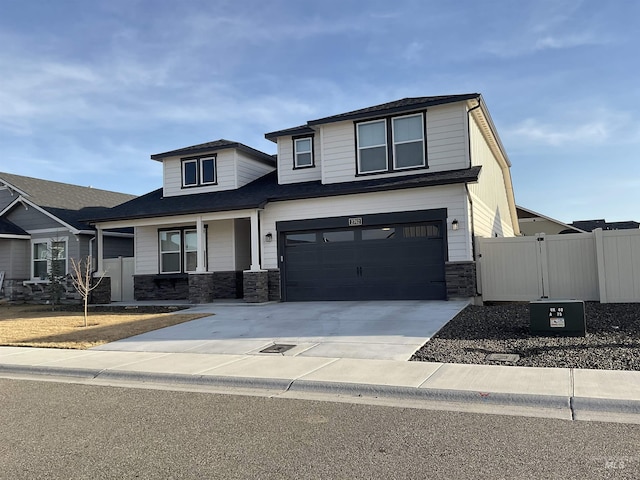 view of front of property featuring a gate, fence, concrete driveway, a garage, and stone siding