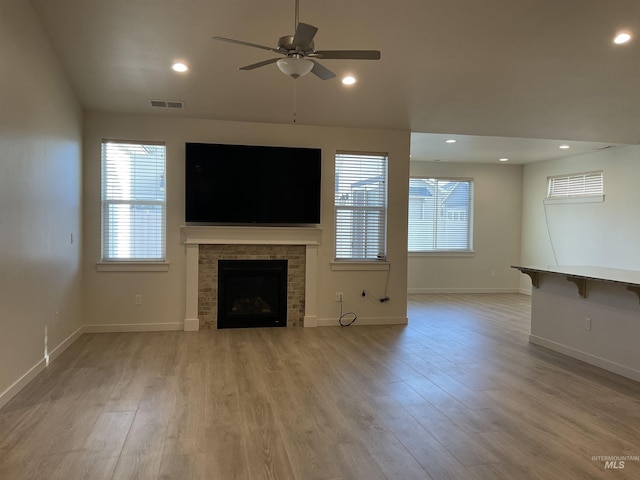 unfurnished living room with light wood-type flooring, visible vents, recessed lighting, and a fireplace