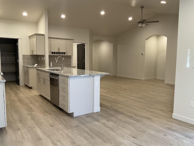 kitchen with a sink, arched walkways, light wood-style flooring, and a ceiling fan