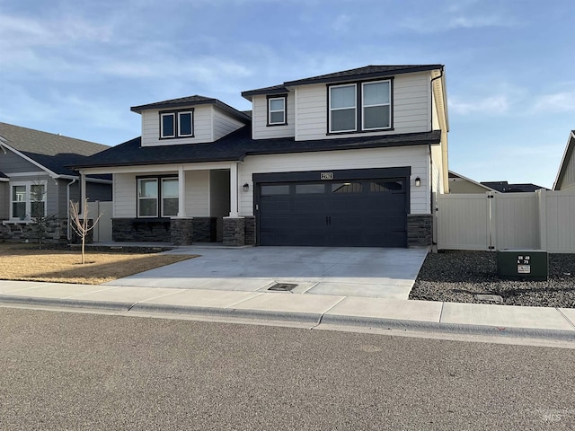 view of front of home with a gate, stone siding, concrete driveway, and fence