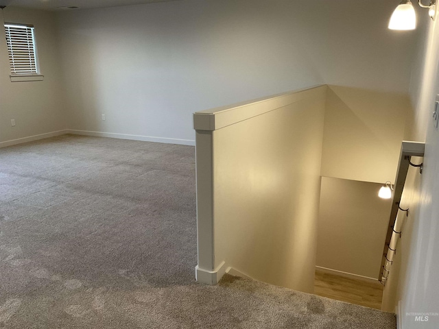 carpeted empty room featuring baseboards