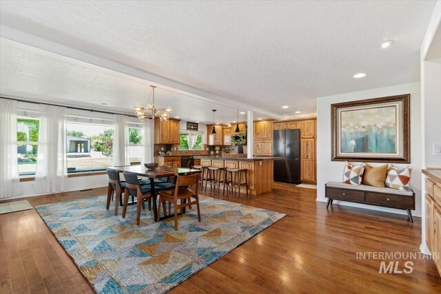 511 Keogh Ln, Caldwell, ID 83607 - dining room with a chandelier, a textured ceiling, hardwood / wood-style floors, recessed lighting, and baseboards