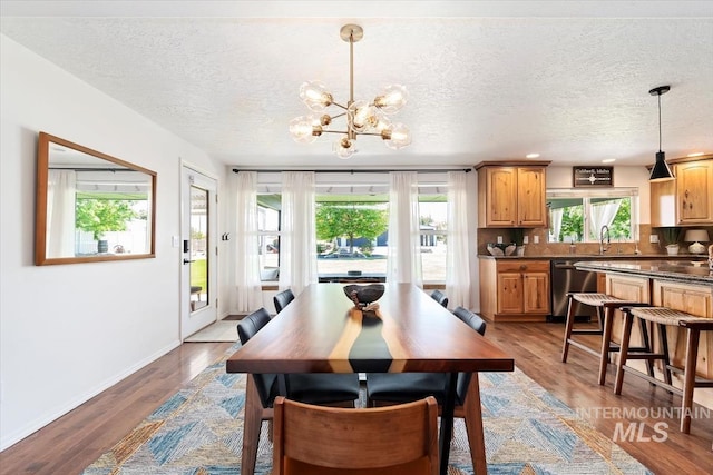 511 Keogh Ln, Caldwell, ID 83607 - dining space featuring a textured ceiling, a chandelier, wood finished floors, and baseboards