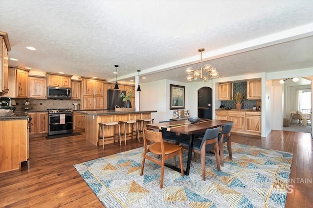 511 Keogh Ln, Caldwell, ID 83607 - dining area featuring arched walkways, dark wood finished floors, recessed lighting, a textured ceiling, and a chandelier