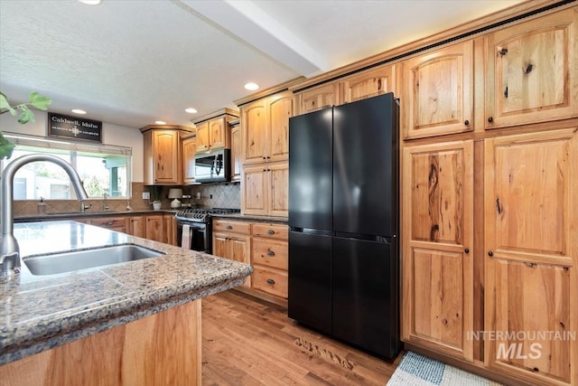 511 Keogh Ln, Caldwell, ID 83607 - kitchen with appliances with stainless steel finishes, a sink, light wood-style flooring, recessed lighting, and tasteful backsplash