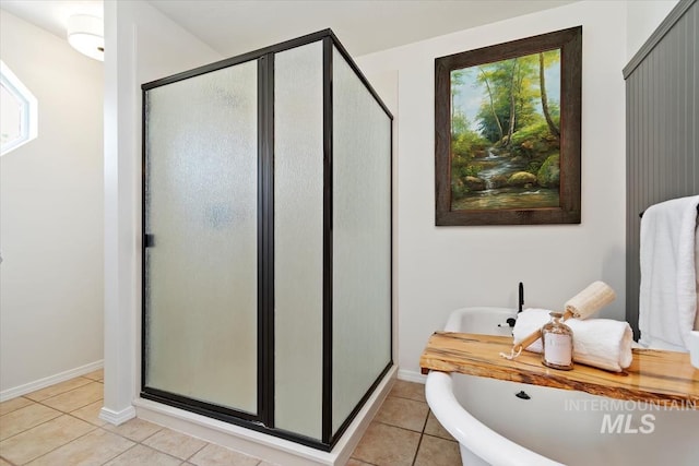 511 Keogh Ln, Caldwell, ID 83607 - bathroom with tile patterned flooring, a shower stall, a soaking tub, and baseboards