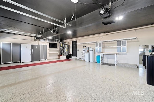 511 Keogh Ln, Caldwell, ID 83607 - garage featuring freestanding refrigerator, a garage door opener, and water heater