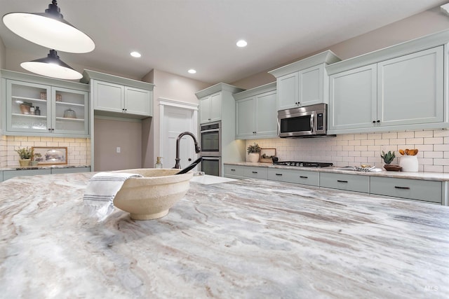 5404 S Palatino Ave, Meridian, ID 83642 - kitchen with appliances with stainless steel finishes, glass insert cabinets, tasteful backsplash, and recessed lighting