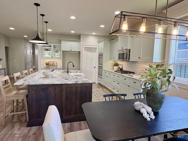 5404 S Palatino Ave, Meridian, ID 83642 - kitchen featuring appliances with stainless steel finishes, tasteful backsplash, recessed lighting, and light wood-style flooring