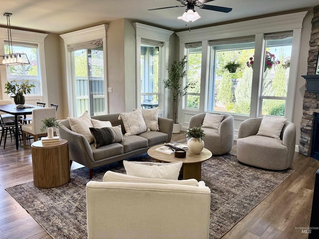 5404 S Palatino Ave, Meridian, ID 83642 - living room with wood finished floors, a ceiling fan, a stone fireplace, and a chandelier