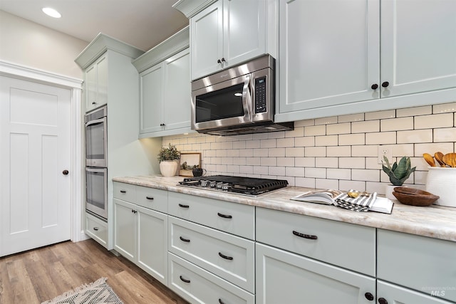 5404 S Palatino Ave, Meridian, ID 83642 - kitchen with appliances with stainless steel finishes, light wood-style flooring, backsplash, and recessed lighting