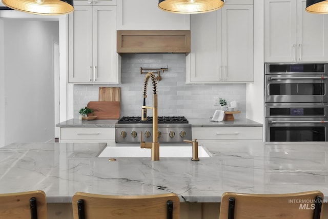 kitchen featuring decorative backsplash, double oven, and white cabinets