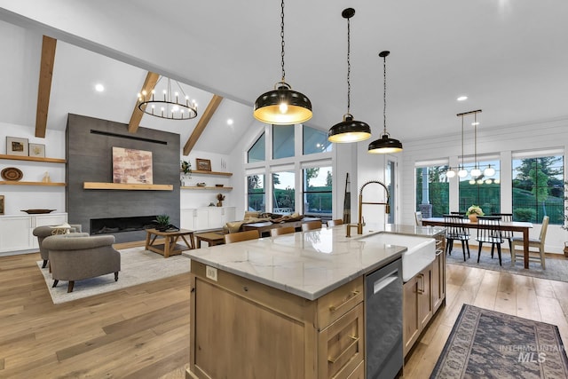 kitchen featuring a sink, a chandelier, light wood-type flooring, light stone counters, and recessed lighting