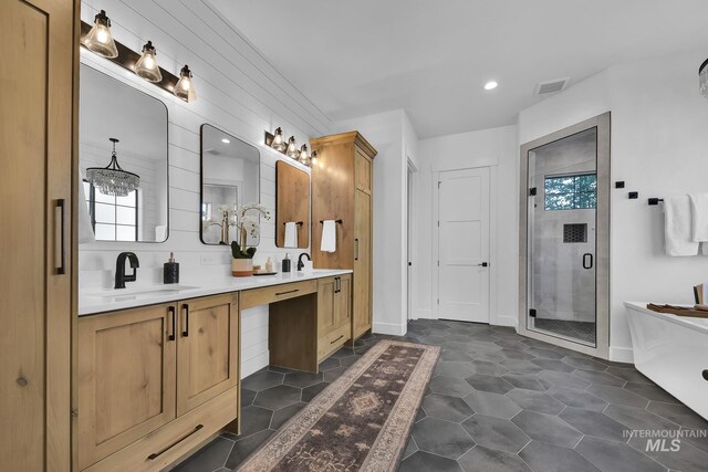 full bath featuring a shower stall, double vanity, recessed lighting, a freestanding bath, and tile patterned floors