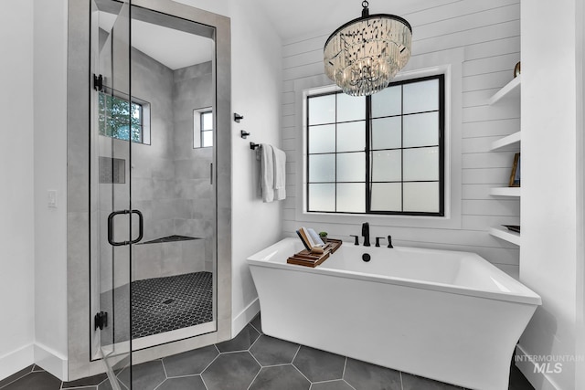full bath featuring a stall shower, a soaking tub, tile patterned flooring, and baseboards