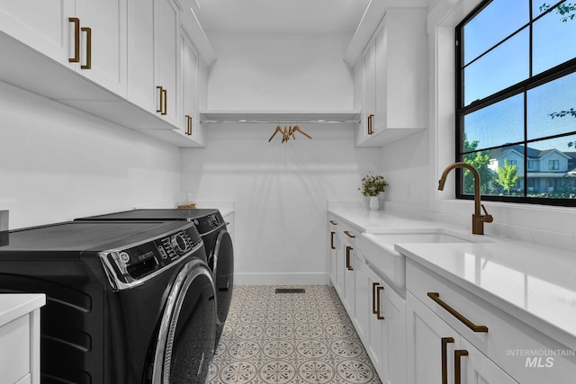 laundry area with cabinet space, washing machine and clothes dryer, and baseboards