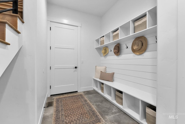 mudroom with unfinished concrete floors and baseboards