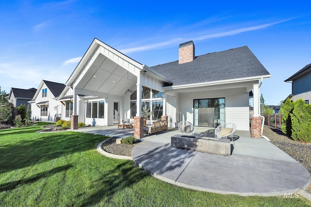 back of house with a ceiling fan, a patio area, and a chimney