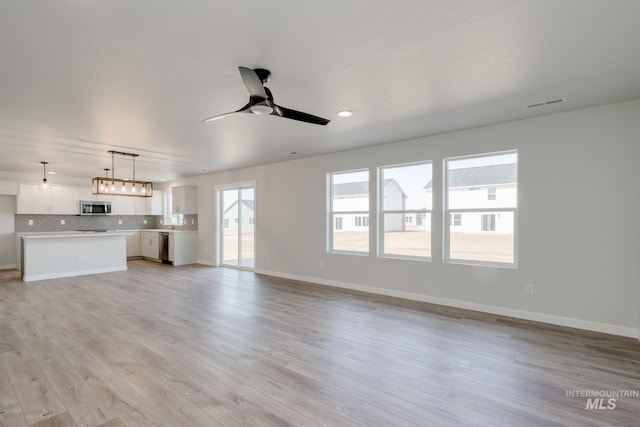 unfurnished living room with ceiling fan, baseboards, light wood-style floors, and visible vents