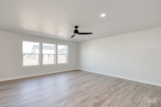 unfurnished room featuring light wood finished floors, a ceiling fan, and baseboards