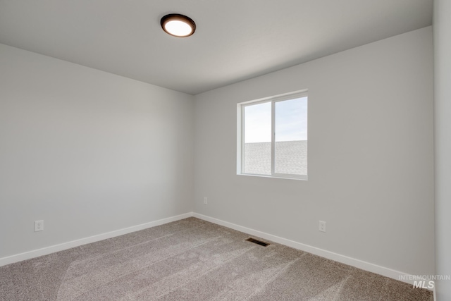 carpeted empty room with baseboards and visible vents