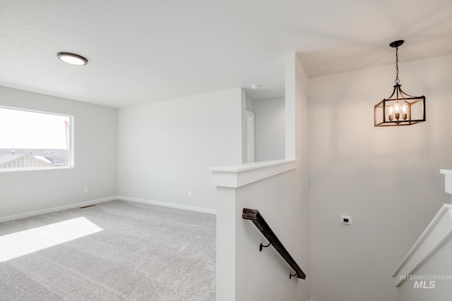 stairs featuring baseboards, carpet flooring, and a chandelier