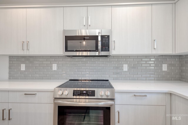 kitchen featuring light countertops, appliances with stainless steel finishes, and tasteful backsplash