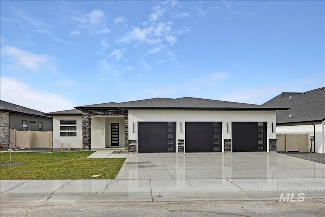 prairie-style home featuring a front lawn and a garage