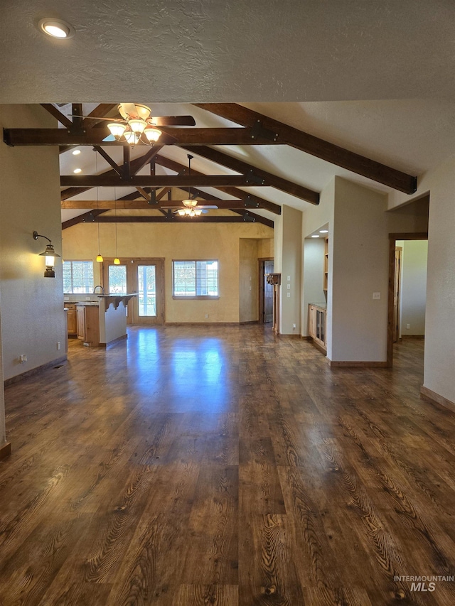 unfurnished living room with a textured ceiling, ceiling fan, beam ceiling, high vaulted ceiling, and dark hardwood / wood-style floors