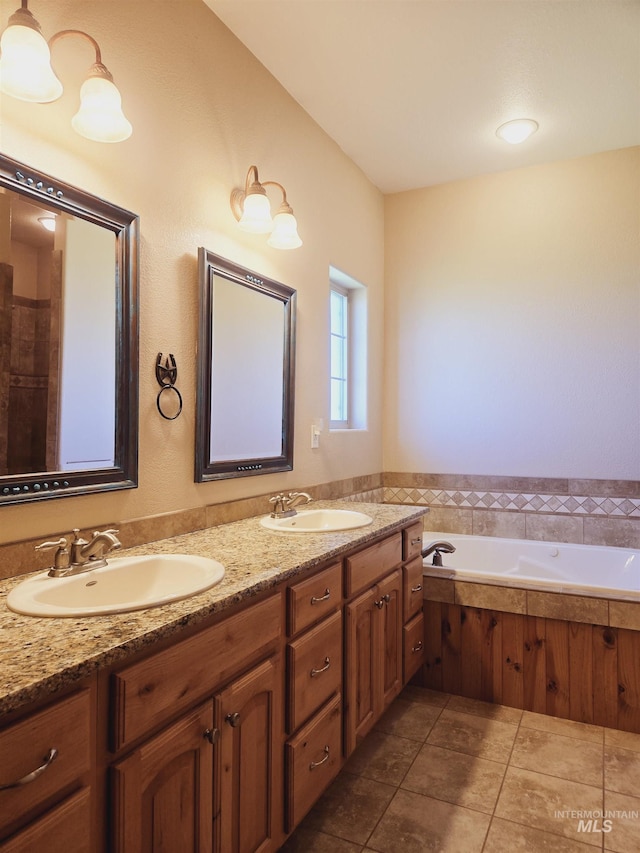 bathroom featuring a washtub, vanity, and tile patterned floors