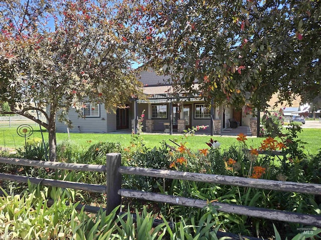 view of property hidden behind natural elements with a front lawn