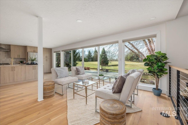 living room featuring a textured ceiling and light wood-style floors