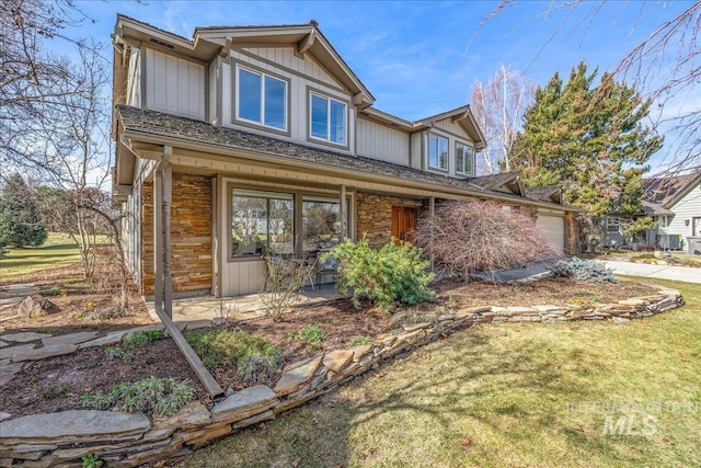 view of front of property with a front yard, a garage, and board and batten siding