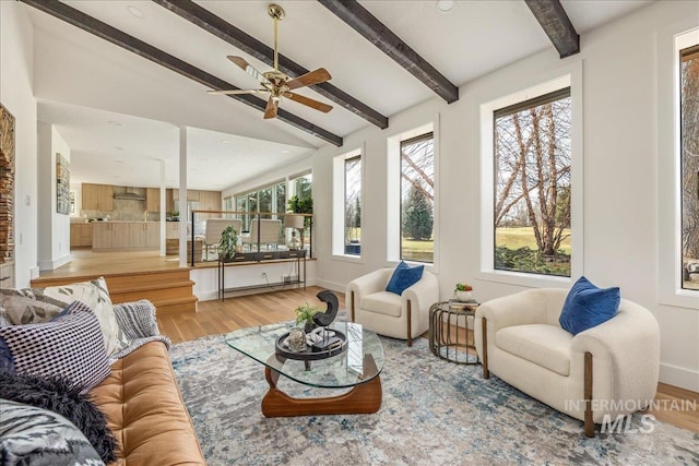 living room with a baseboard heating unit, vaulted ceiling with beams, wood finished floors, and baseboards