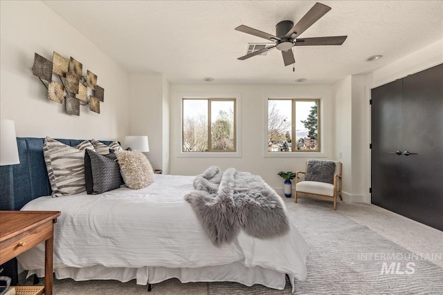 bedroom with carpet floors, a textured ceiling, and ceiling fan