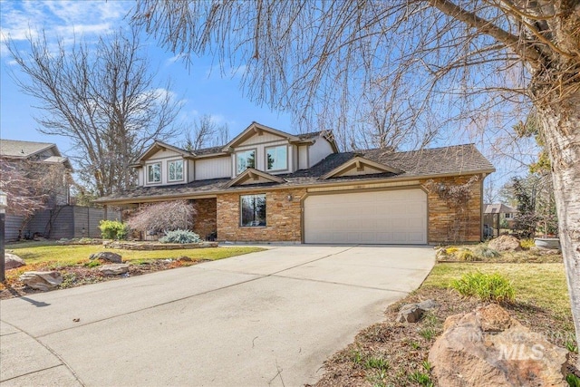 view of front of property featuring an attached garage, driveway, and fence