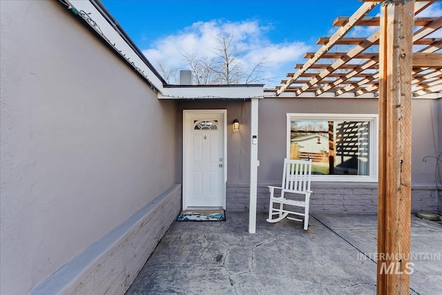 view of exterior entry with a patio