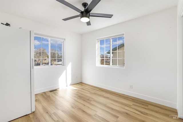 unfurnished room featuring ceiling fan, light wood-type flooring, and baseboards