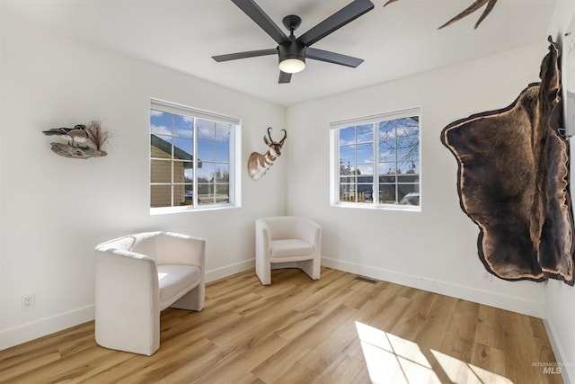 sitting room featuring visible vents, wood finished floors, a ceiling fan, and baseboards