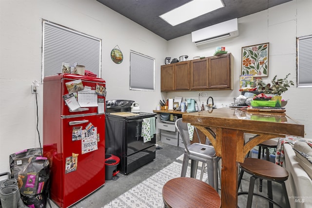 kitchen with black range with electric cooktop, brown cabinets, freestanding refrigerator, concrete flooring, and a wall mounted air conditioner