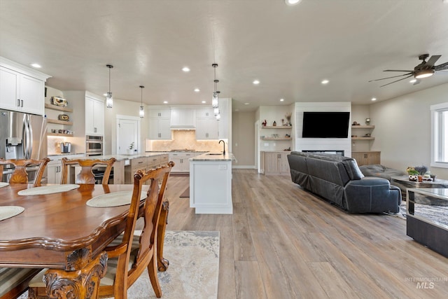 6623 Red Rock Rd, Marsing, ID 83639 - dining room with light wood-style flooring, a ceiling fan, recessed lighting, and a fireplace