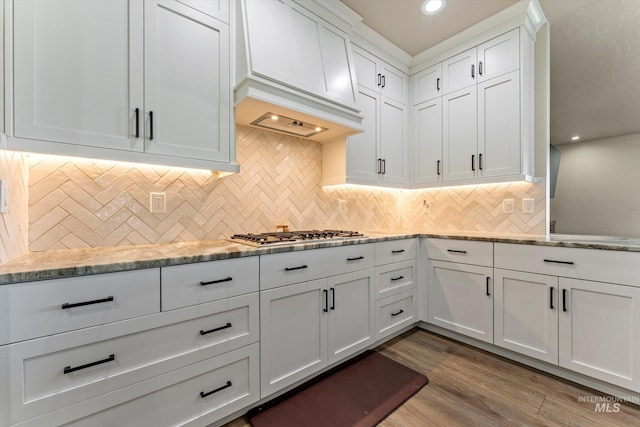 6623 Red Rock Rd, Marsing, ID 83639 - kitchen featuring stainless steel gas stovetop, white cabinets, dark wood-style flooring, premium range hood, and decorative backsplash