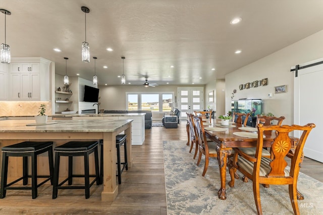 6623 Red Rock Rd, Marsing, ID 83639 - dining space featuring a barn door, recessed lighting, wood finished floors, and a ceiling fan