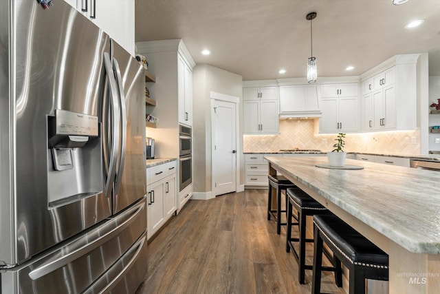6623 Red Rock Rd, Marsing, ID 83639 - kitchen featuring stainless steel appliances, a kitchen breakfast bar, dark wood finished floors, recessed lighting, and white cabinetry