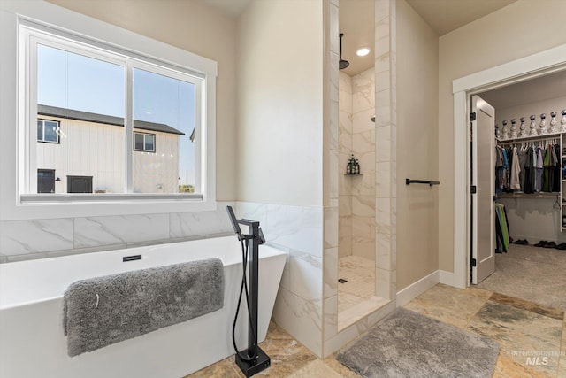 6623 Red Rock Rd, Marsing, ID 83639 - bathroom with a freestanding tub, a walk in shower, a spacious closet, and stone finish flooring