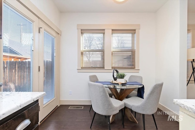 dining space with visible vents, dark wood-type flooring, and baseboards