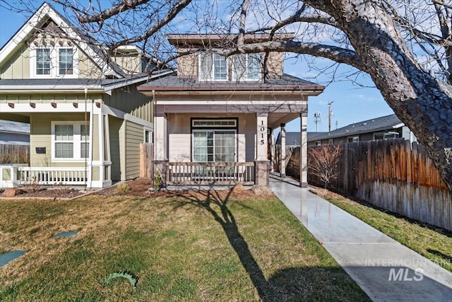 view of front facade featuring board and batten siding, covered porch, and fence