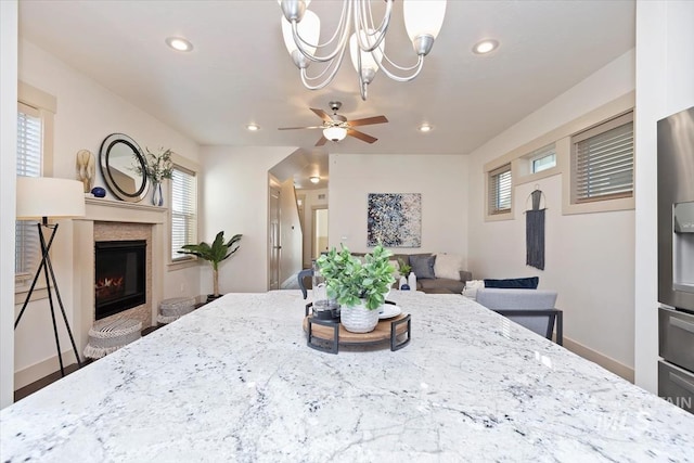 dining space with recessed lighting, baseboards, a glass covered fireplace, and a ceiling fan