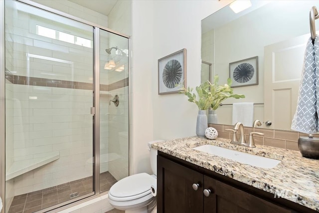 full bath featuring vanity, toilet, and a stall shower